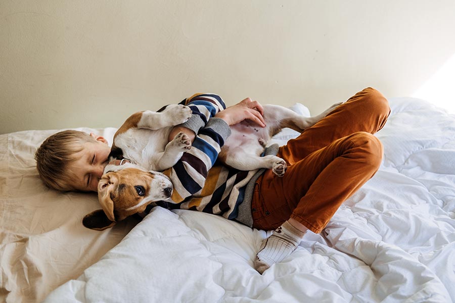 Little boy laying with their dog